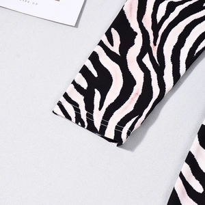 Close-up of zebra print sleeve cuff with pink details and premium knit fabric texture