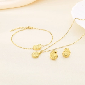 Detailed view of gold stainless steel nautilus shell pendant necklace and earrings set