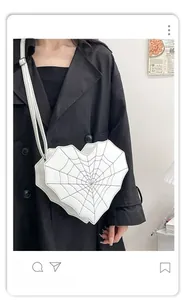 Sac cœur avec motif toile d'araignée porté par un mannequin en manteau noir chic