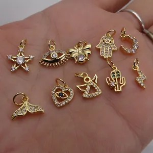 Selection of 10 gold-plated charms with zircon inlays including star, moon, and bee shapes