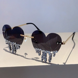 Close-up of heart-shaped rimless sunglasses with purple lenses and crystal drop detail