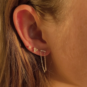 Macro shot of 925 silver gold-plated stud set with baguette and round zircons