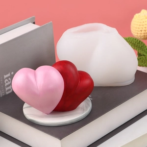 Detailed view of 3D woven heart silicone mold with finished pink and red candles