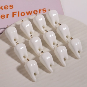 Set of 12 creative white resin tooth-shaped pendants with golden metal hanging loops
