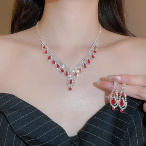 Detail view of crystal water drop tassel necklace and earrings set with red rhinestones