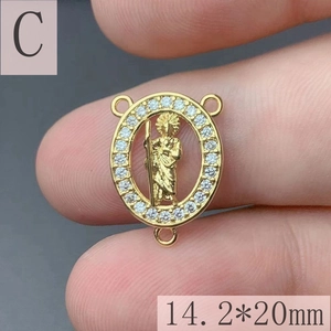 Macro view of gold Saint Benedict pendant with white cubic zirconia and 3-ring connector