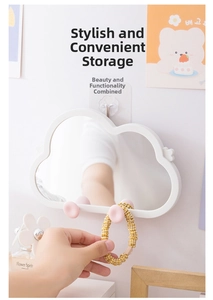 Cloud-shaped wall mirror detail with white frame and two pink hooks for accessories