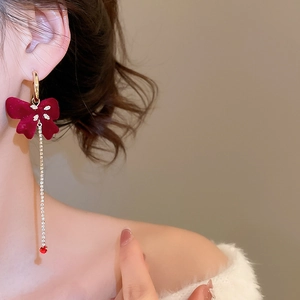 Detail of red flocked bow earring with sparkling long tassel and ruby teardrop pendant