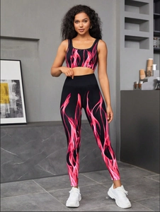 Detail of high-stretch seamless yoga set with pink flame gradient print on black fabric
