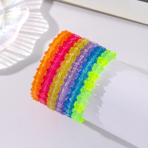 Detail of multi-colored star-shaped acrylic bracelets with glitter inside beads