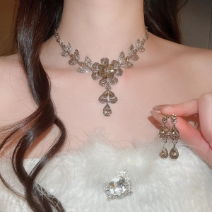 Close-up of elegant champagne flower necklace and earrings set worn by a model