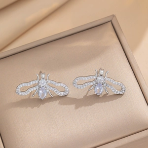 Makroaufnahme von Bienen-Ohrsteckern in Silber mit Zirkonia und blauen Steinen auf Schmuckbox
