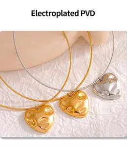 Close-up of gold and silver fluid heart pendants with PVD plating and textured surface