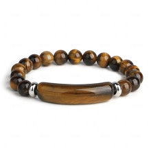 Macro shot of tiger eye stone beads and polished silver metal spacers on men's bracelet