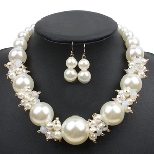 Detail shot of a multi-layer white pearl necklace and earring set on a black mannequin bust