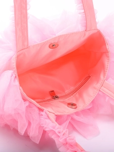 Detail view of pink ruffled tulle bag showing silver magnetic closure and inner zipper pocket