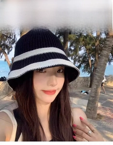 Outdoor model show featuring a black and white striped knitted bucket hat for sun protection