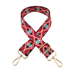 Ethnic style embroidered bag strap with red, black and white patterns and gold hardware