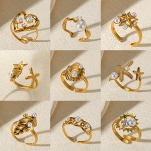 Detail of nine golden adjustable rings with pearls and sparkling zircon nautical charms