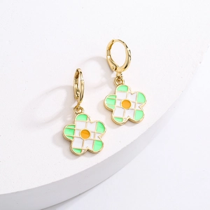 Close-up of 18K gold plated floral hoop earrings with white and green enamel detailing