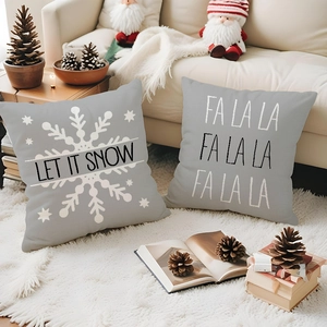 Detail of gray linen Christmas pillow covers with white snowflakes and festive text prints