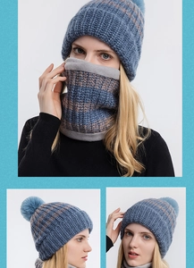 Dettaglio del cappello in maglia blu e marrone con pompon e fodera in pile grigio