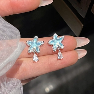 Nahaufnahme von Stern-Ohrstecker mit blauem Marmor-Inlay und Tropfen-Edelstein