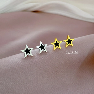 Titanium steel star earrings in gold and silver finish on purple silk background