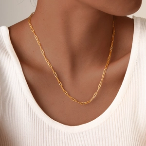 Gold stainless steel rectangle link necklace with textured facets on a female model