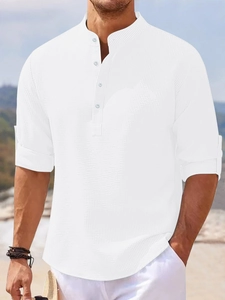 Detail of white waffle texture long sleeve polo shirt with stand collar and buttons
