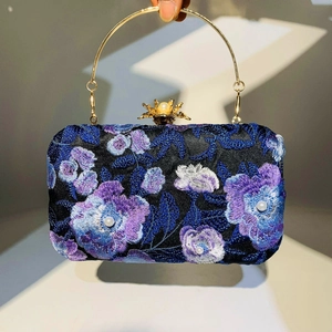 Detailed embroidery on navy evening bag with 3D floral pearls and golden metal ring handle
