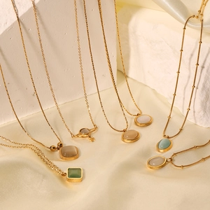 Artistic layout of gold titanium necklaces with cat-eye stone and pearl pendants