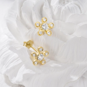 Macro shot of S925 sterling silver stamp on golden five-petal flower zircon earring