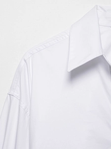 Close-up of white V-neck shirt showing sharp collar points and precise shoulder stitching