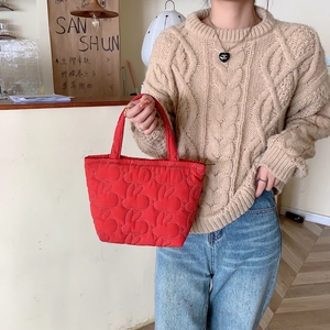 Detailed view of red quilted tote bag with cute rabbit pattern and soft top handles