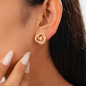 Close-up of elegant gold twisted pearl earrings worn by a model for vintage styling