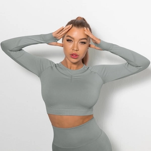 Dettaglio del crop top yoga senza cuciture verde salvia con arricciature e passapollice