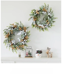 Detail of Christmas wreath with eucalyptus leaves, golden berries and white ornaments