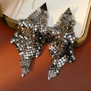 Detail of gun black metallic sequin bow earrings with triangle studs on leather background