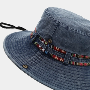 Detail of dark blue denim cowboy hat with ethnic braided band and adjustable wind rope