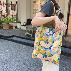 Détail du sac cabas en toile à fleurs style peinture à l'huile avec bandoulière