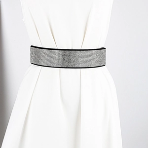 Close-up of wide elastic waist belt with silver rhinestones on a white dress