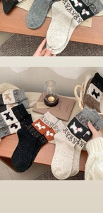 Detail of wool socks featuring festive Fair Isle knit patterns and cute puppy motifs