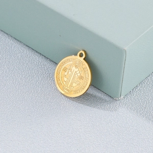 Golden St. Benedict medal pendant in stainless steel displayed on a light blue gift box