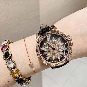 Detail of lady's watch featuring a rotating crystal flower dial and black leather strap