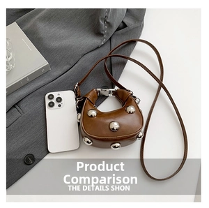 Brown leather crescent bag with silver metallic studs shown next to a smartphone for size comparison