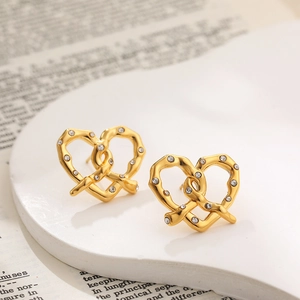Close-up of 18K gold stainless steel interlocking heart earrings with cubic zirconia