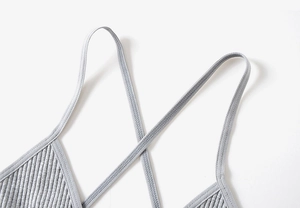 Détail macro de la bralette grise en tricot avec texture côtelée et bretelles croisées