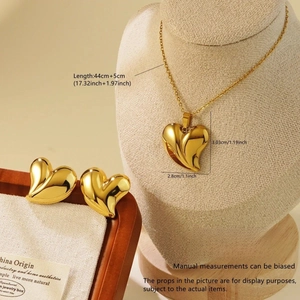 Close-up of golden stainless steel heart jewelry set on a display stand and tray