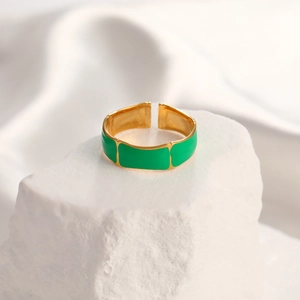 Detail of green enamel bamboo style adjustable ring in gold finish on stone